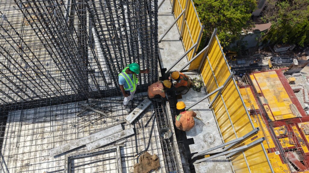 Safety screen system protecting workers & surroundings in high-rise building.